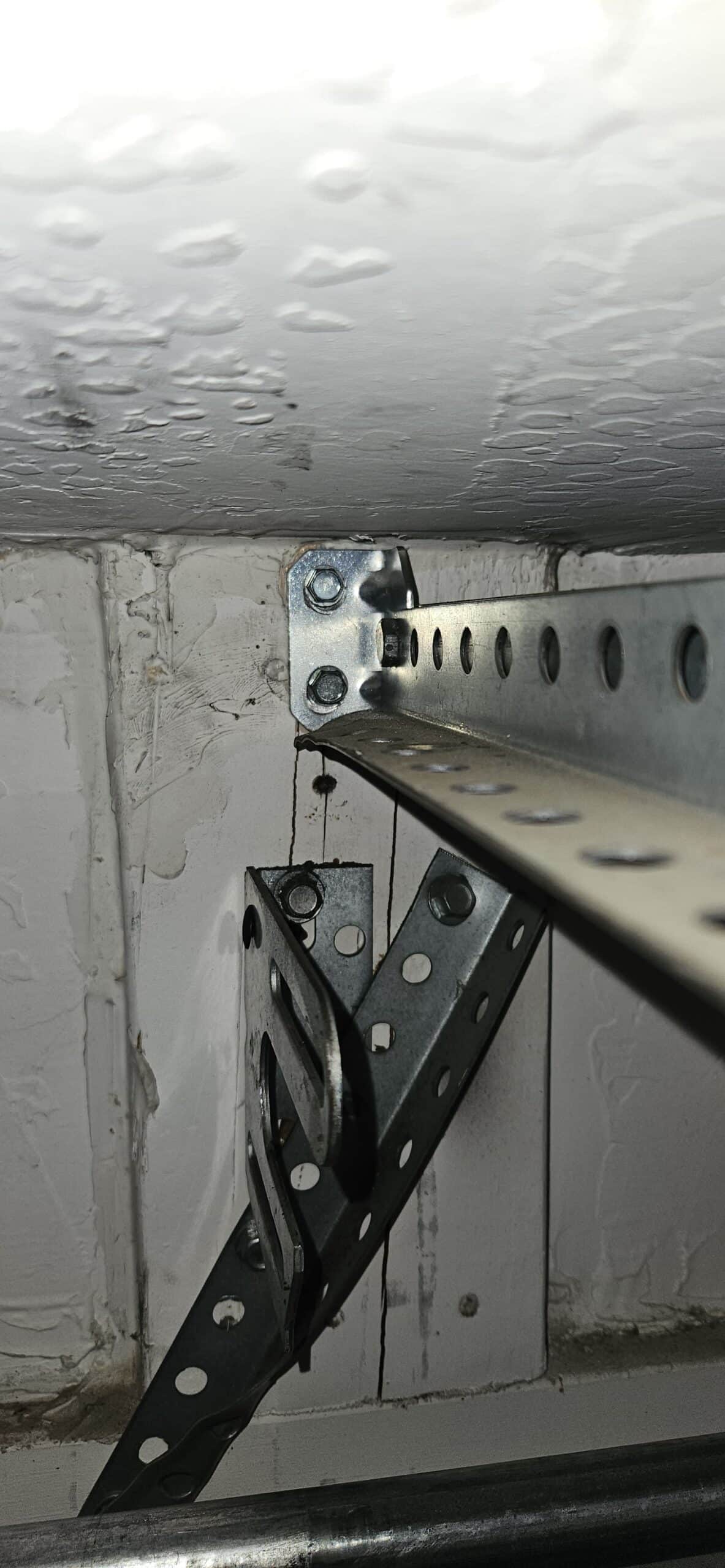 Damaged garage door bracket close up in Glendale
