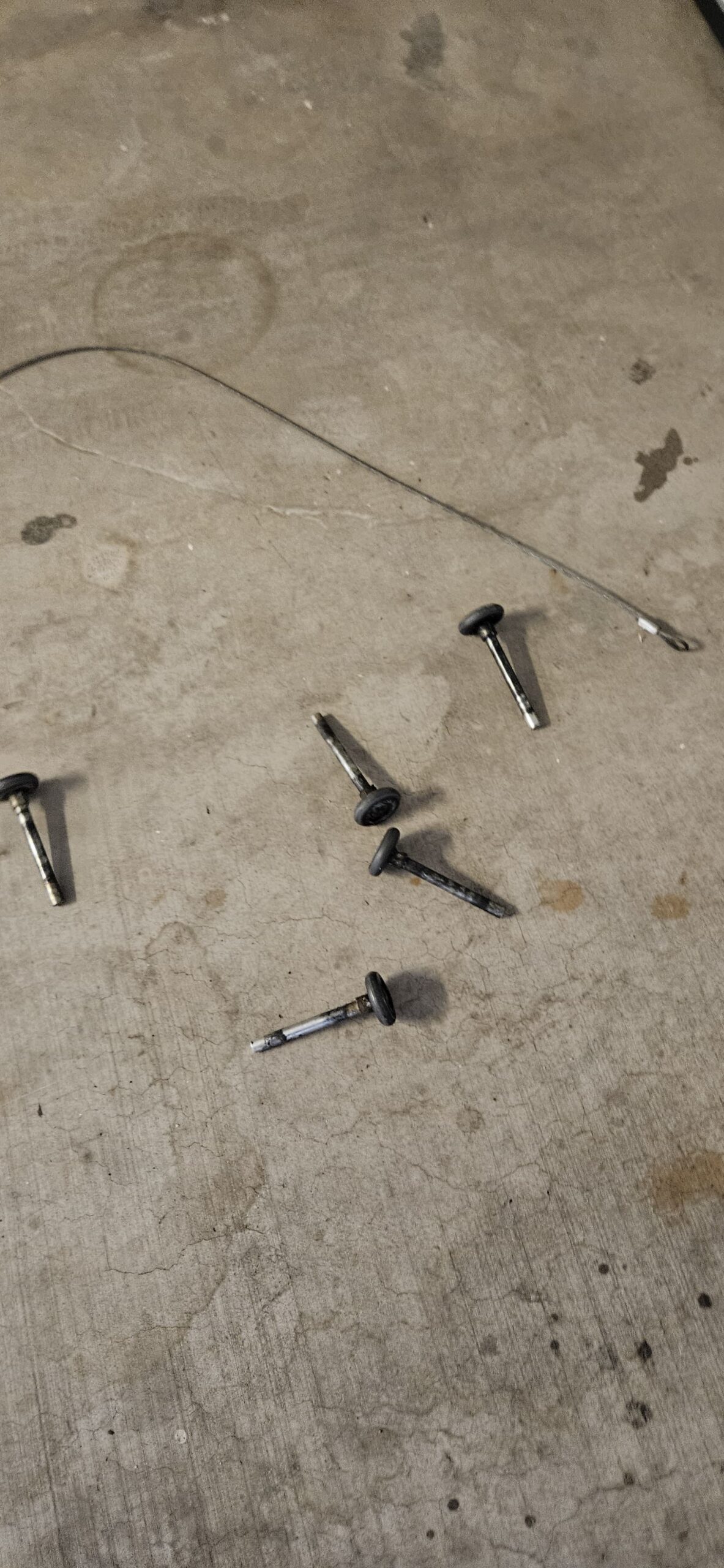 Worn garage door rollers removed during repair in Phoenix